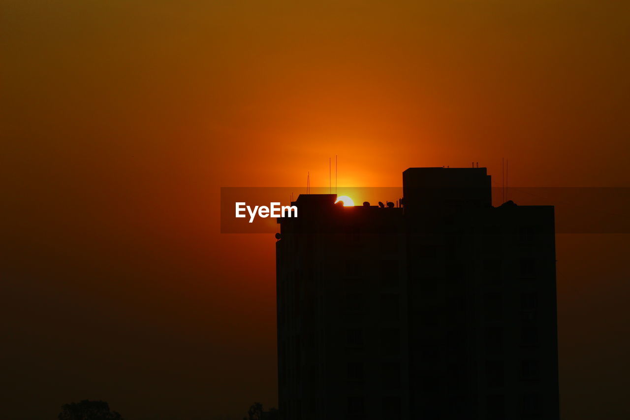 Low angle view of silhouette buildings against sky during sunset