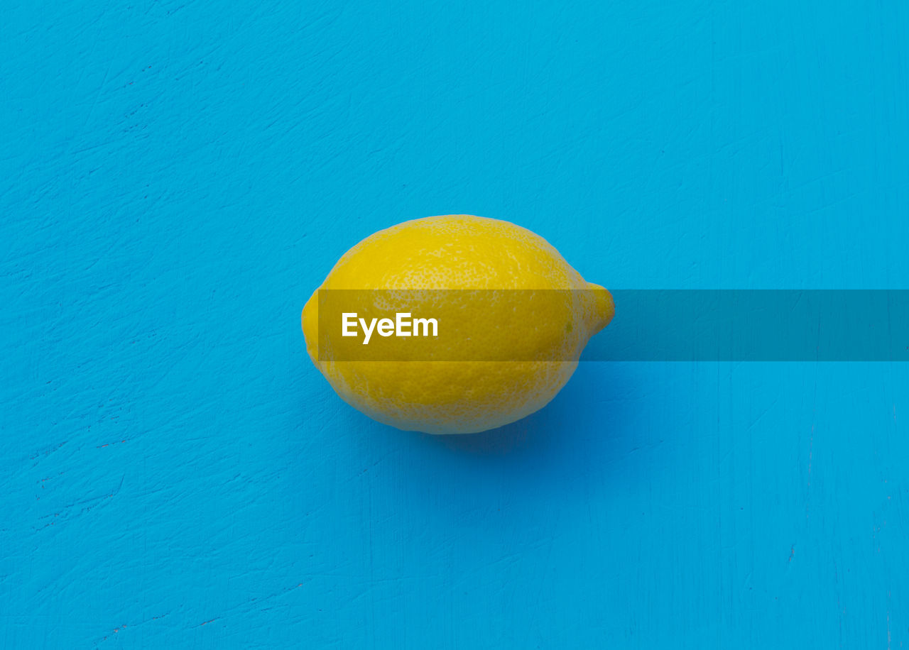 Close-up of lemon against blue background