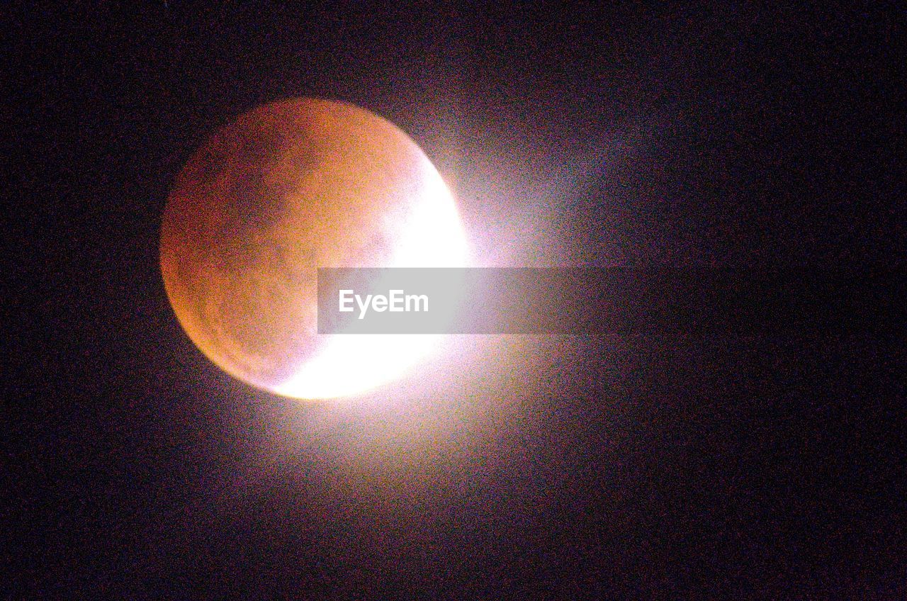 LOW ANGLE VIEW OF SUN SHINNING THROUGH MOON