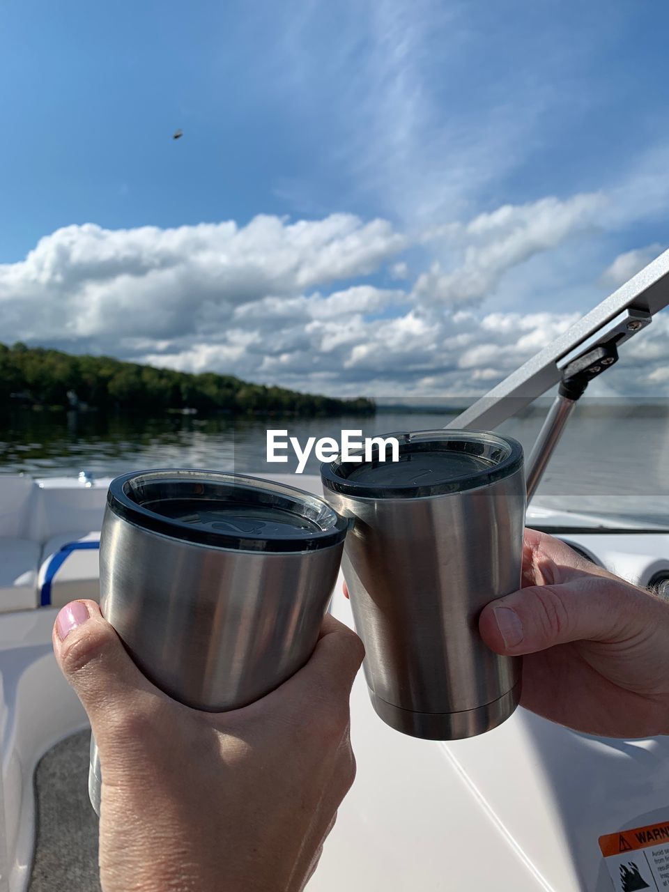 PERSON HOLDING DRINK AGAINST SKY