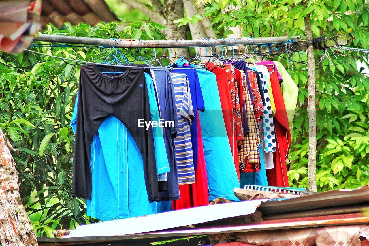 MULTI COLORED CLOTHES HANGING ON CLOTHESLINE