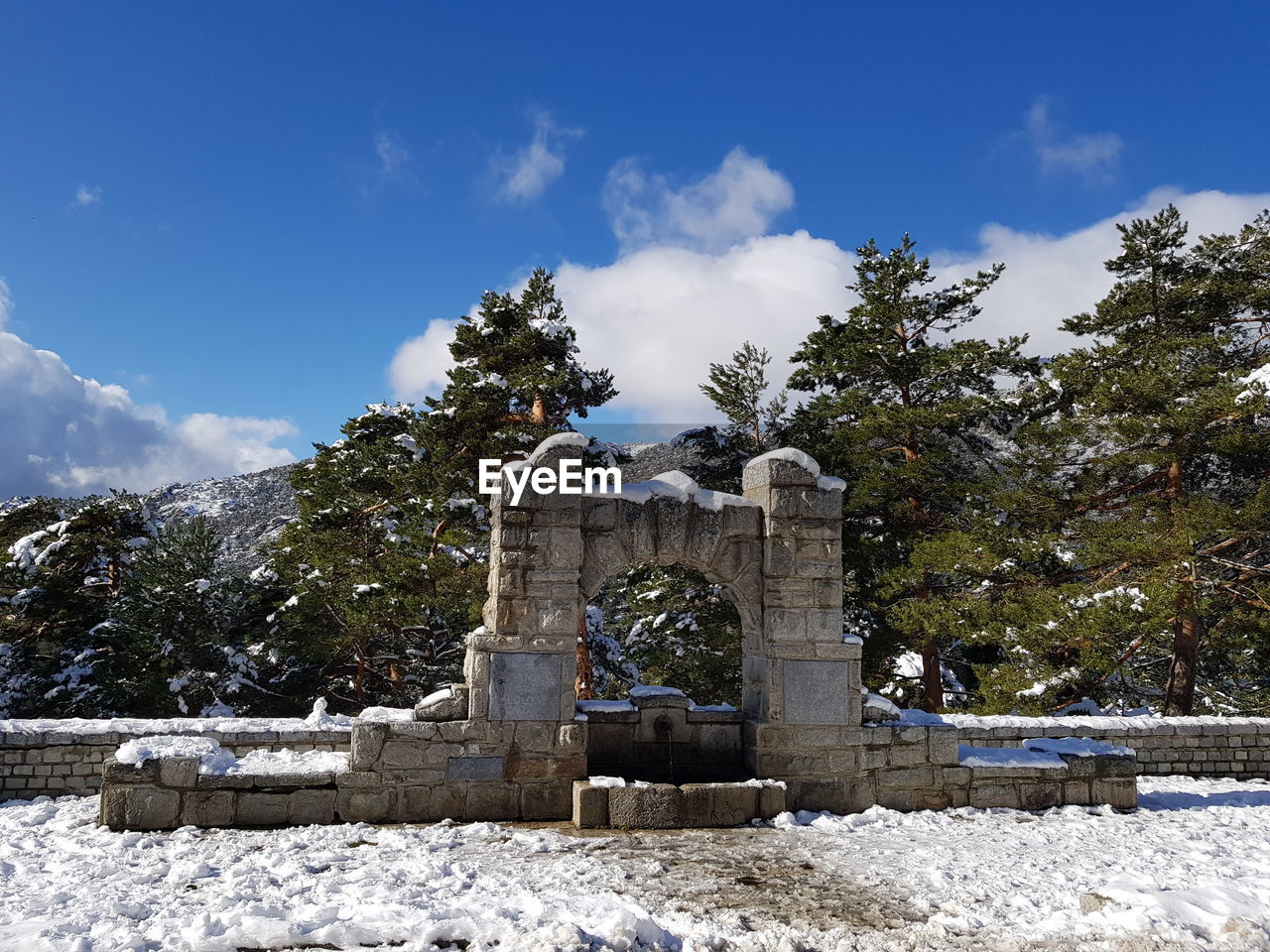 Built structure on snow covered field against sky