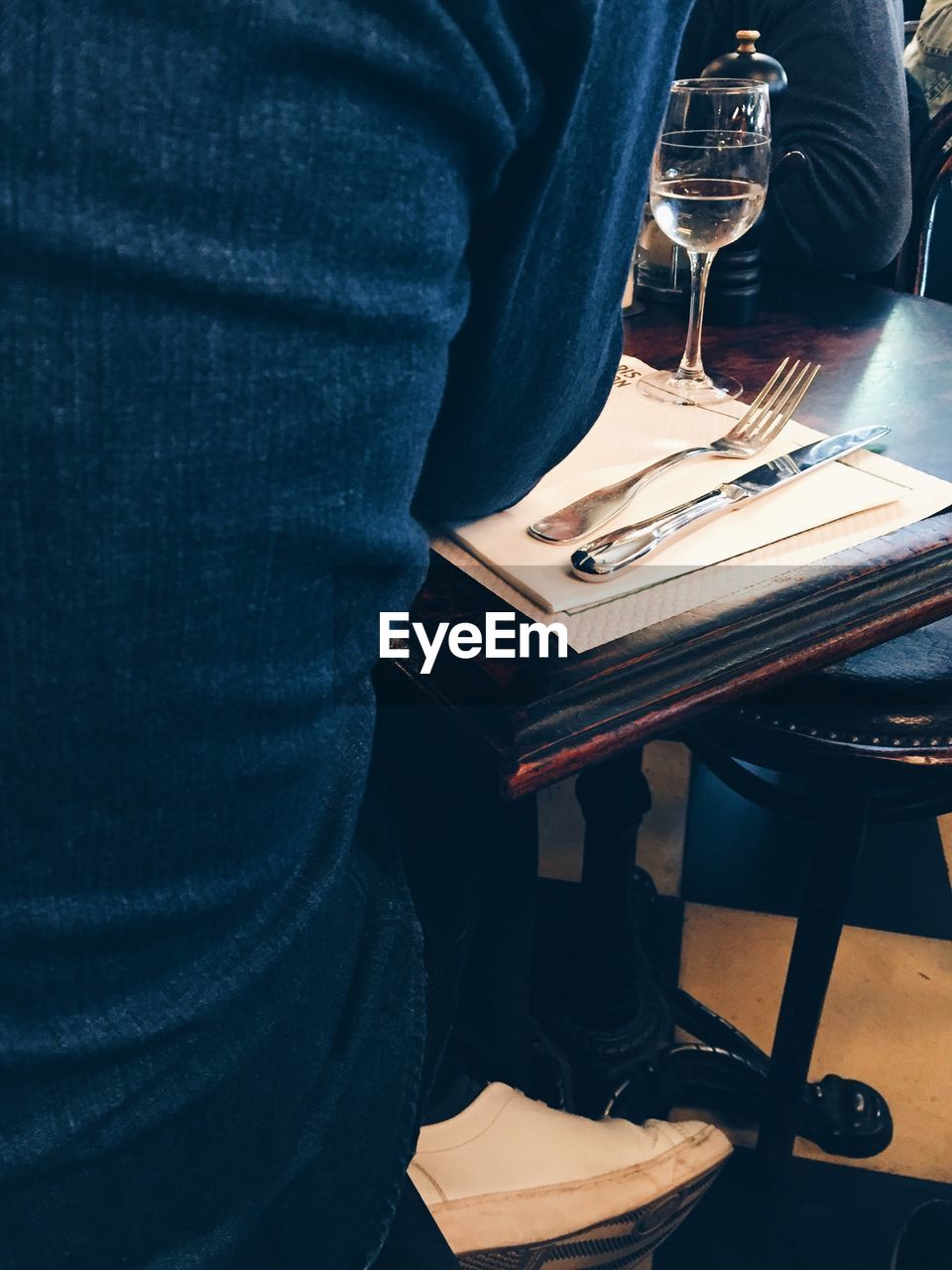 LOW SECTION OF MAN SITTING AT TABLE