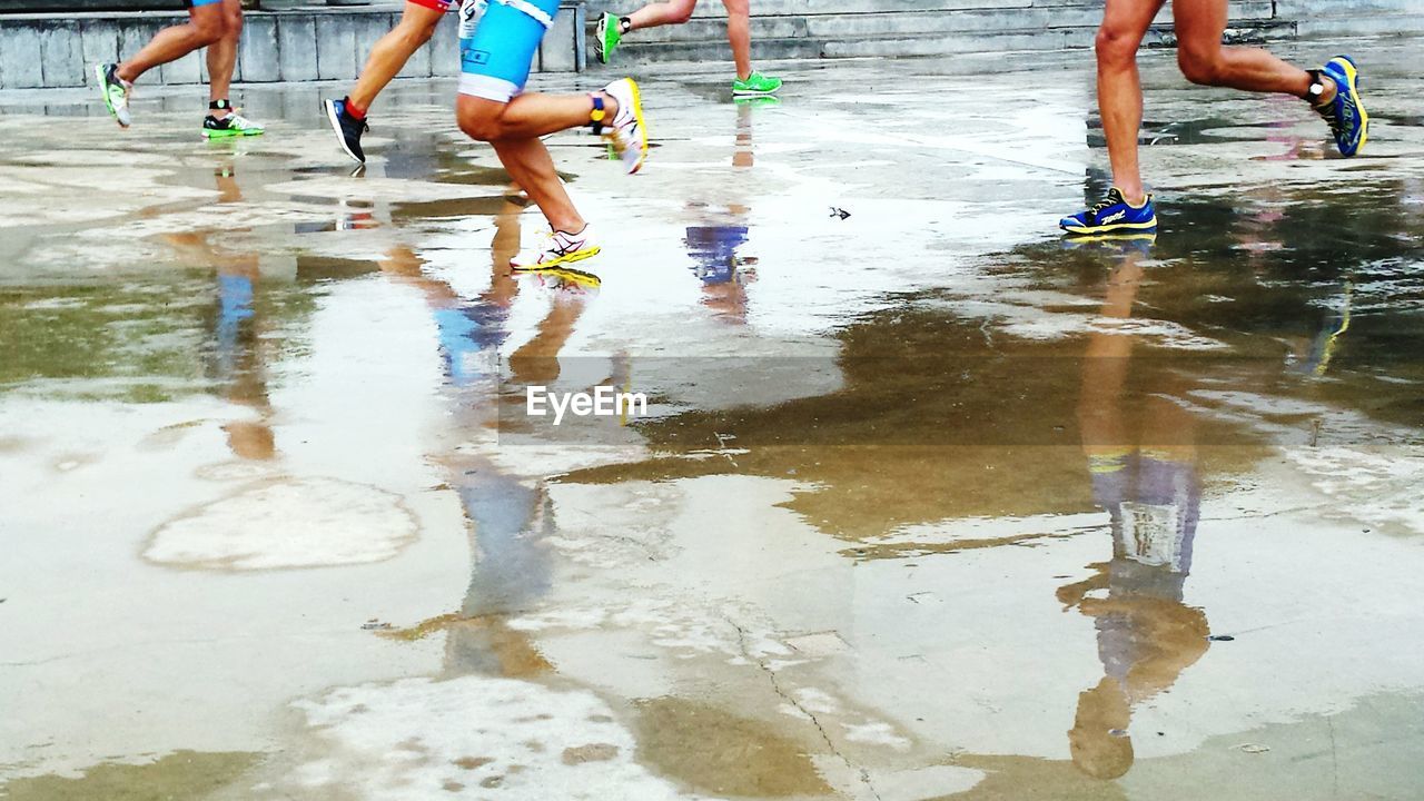 Low section of people running on footpath during rainy season