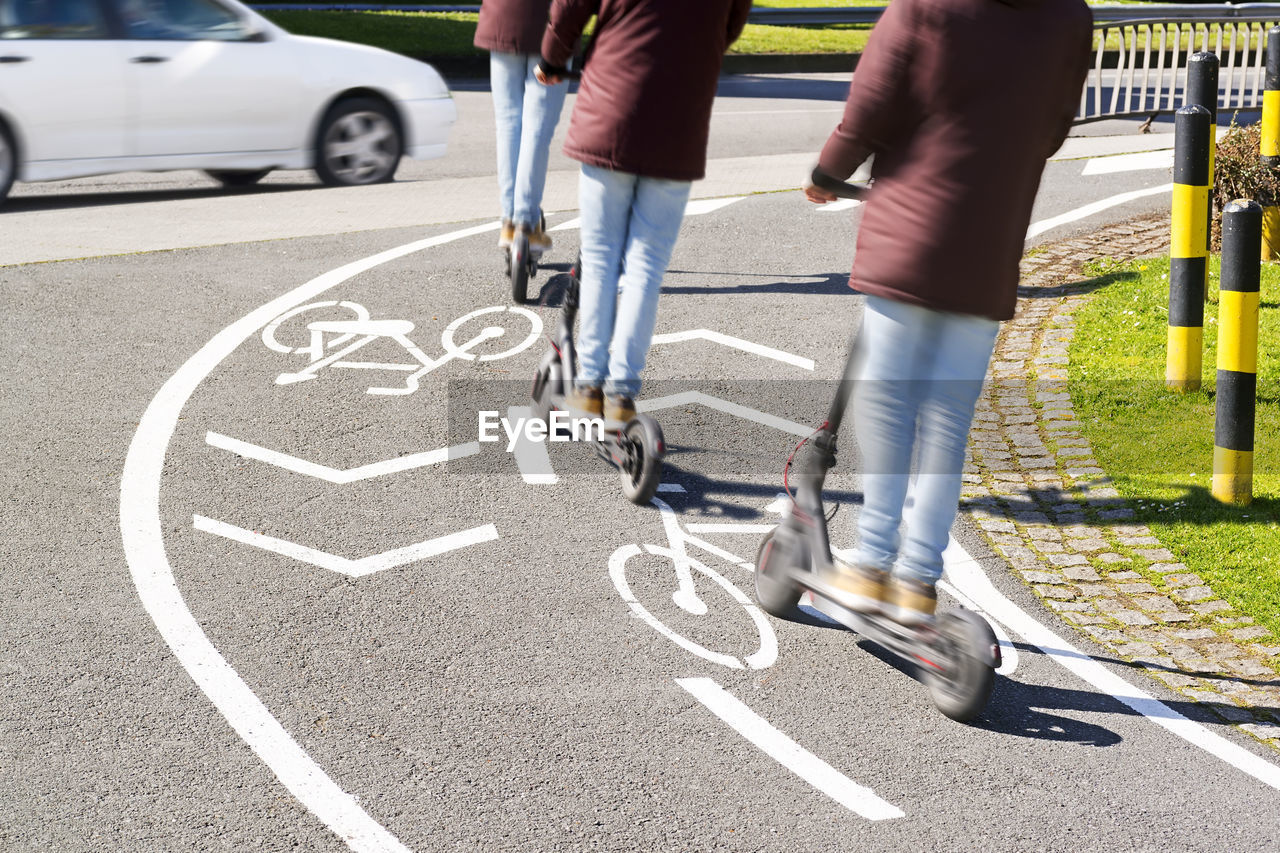 Low section of person riding bicycle on road