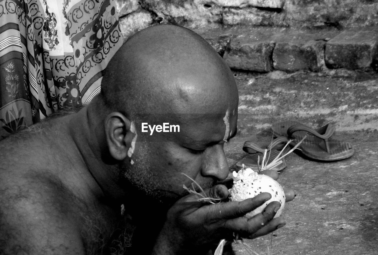Close-up of man smelling flower outdoors