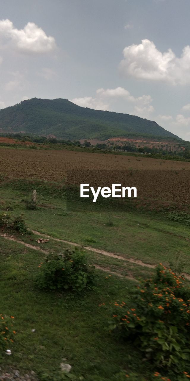 SCENIC VIEW OF FIELD BY MOUNTAINS AGAINST SKY