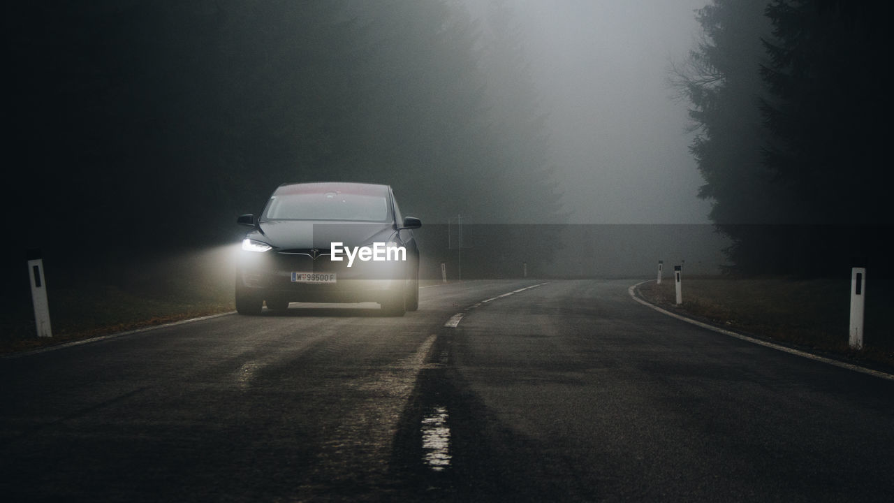 CAR ON ROAD IN FOGGY WEATHER