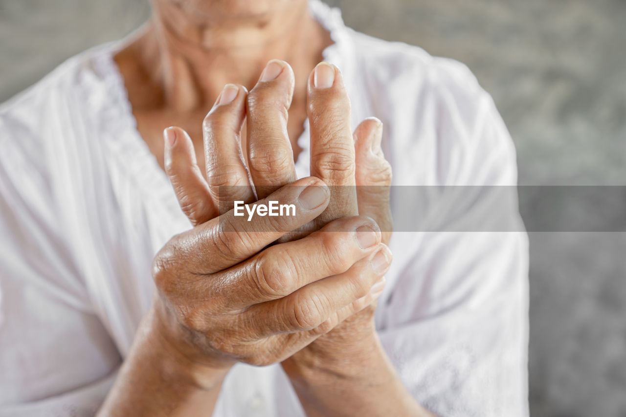 Close-up of senior woman with wrinkled fractured hands