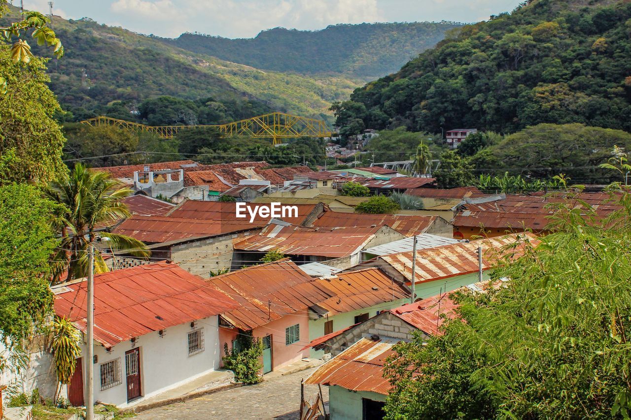 Houses by mountains against sky