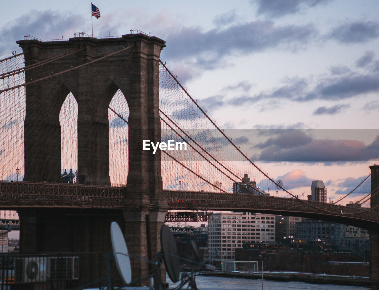 Brooklynbridge over east river against sky during sunset