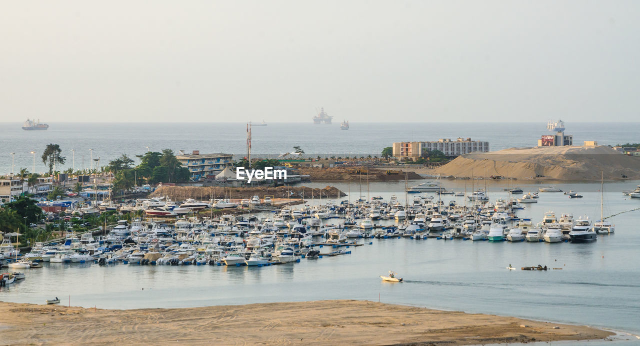 View of harbor against sky in city
