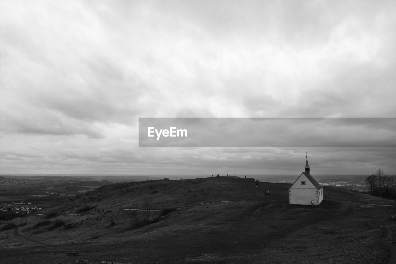 Church on hill against cloudy sky