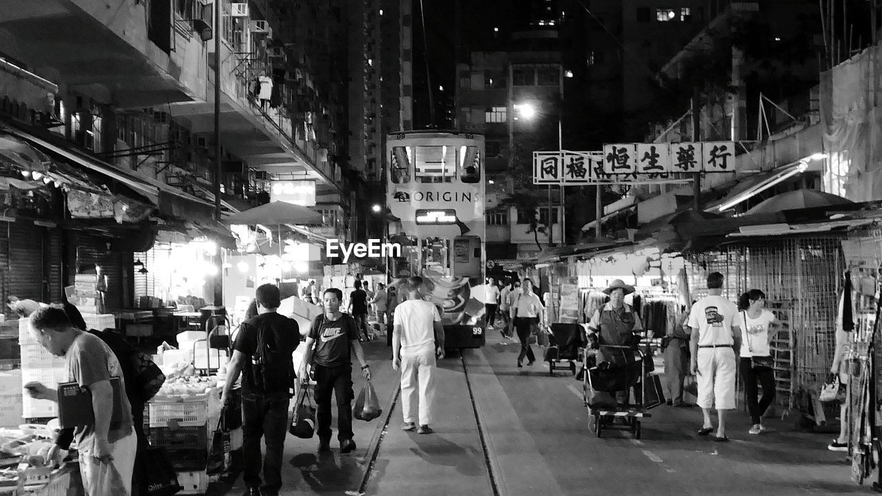 People moving on illuminated city street at night