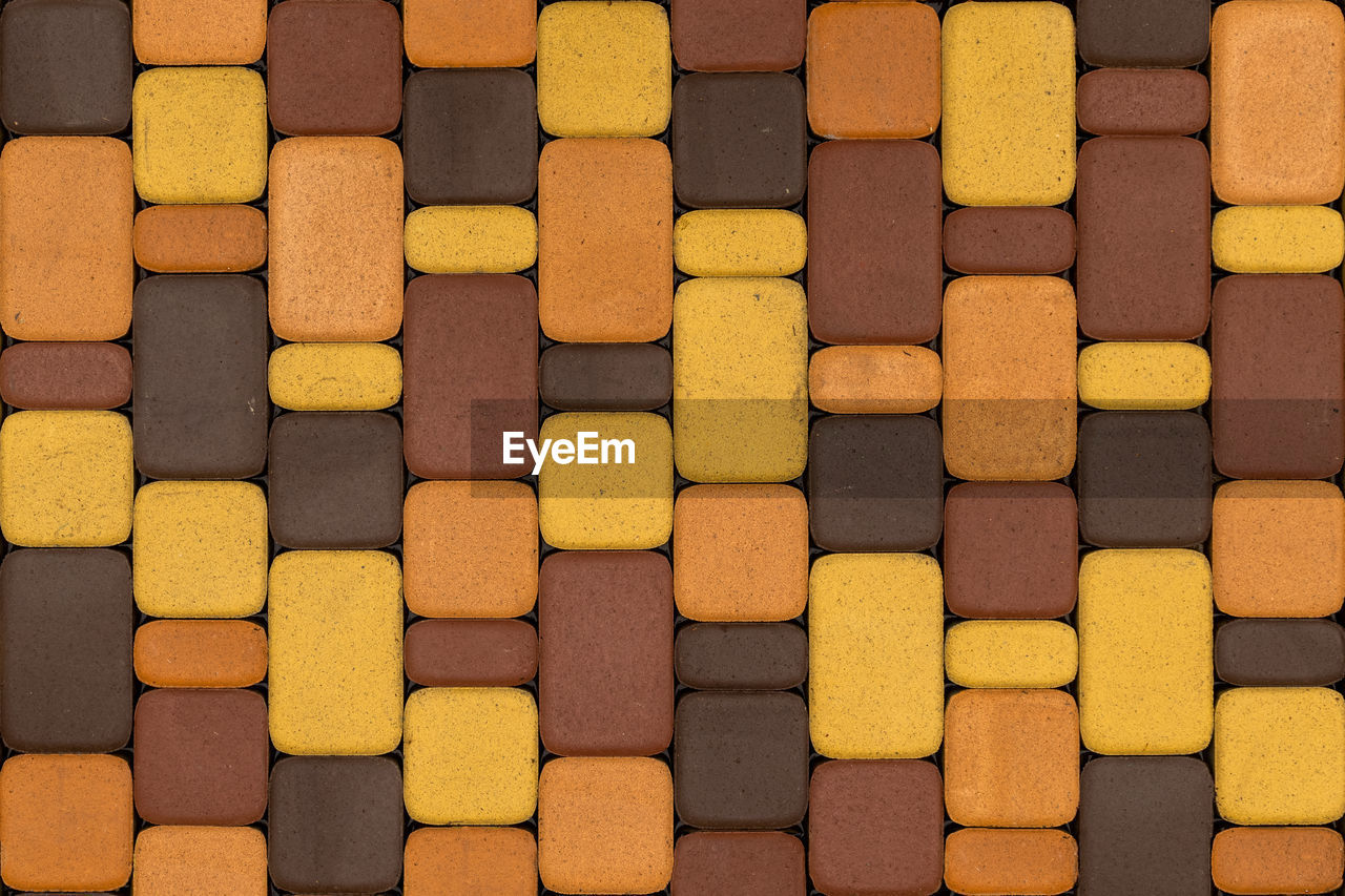 Seamless texture and background of brown and yellow artificial stone pavement