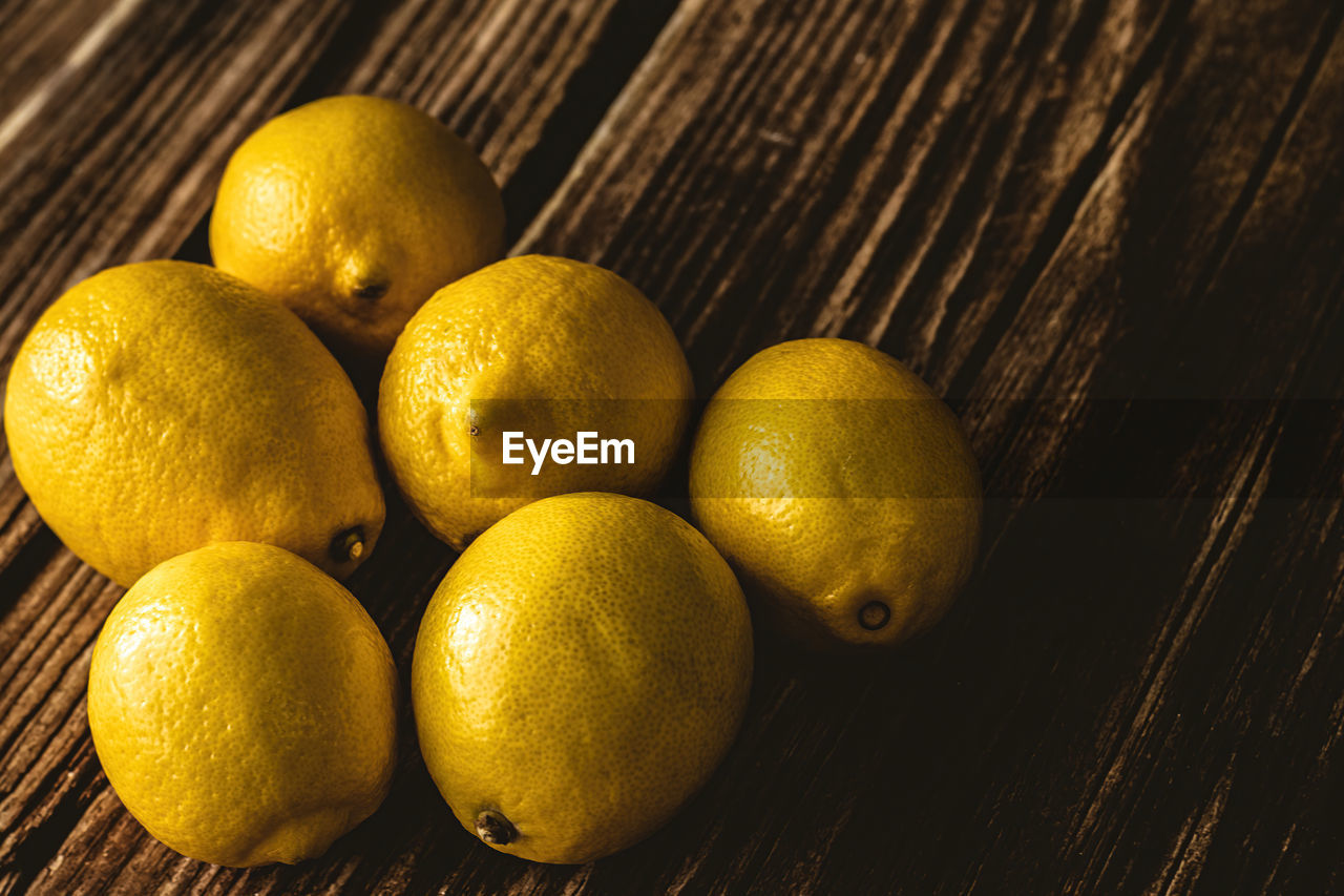 HIGH ANGLE VIEW OF LEMONS IN CONTAINER ON TABLE