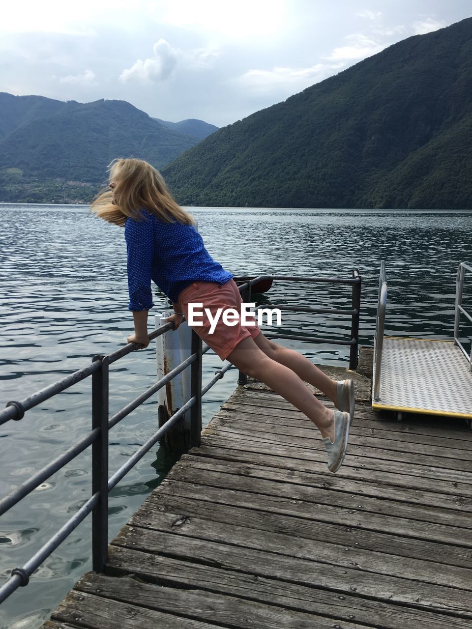 YOUNG WOMAN LOOKING AT LAKE