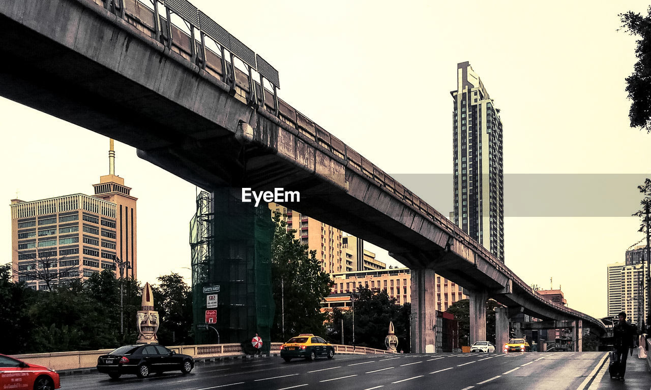 VIEW OF BRIDGE AND CITY BUILDINGS AGAINST CLEAR SKY
