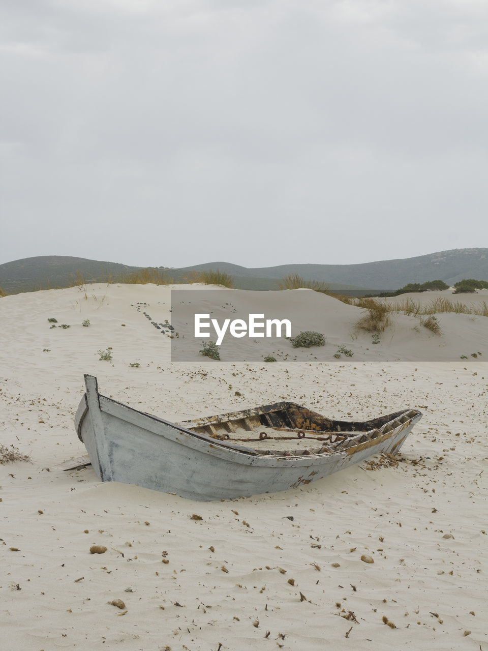 SCENIC VIEW OF SAND DUNE ON BEACH AGAINST SKY