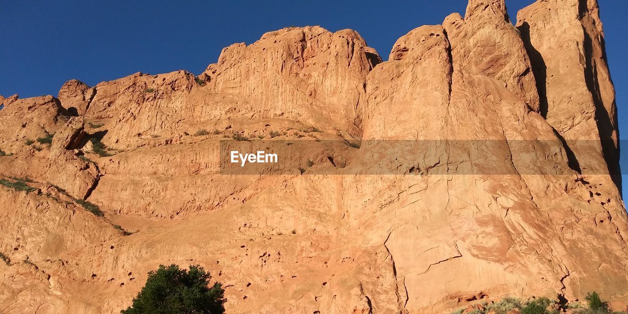 Low angle view of rocky mountains against sky