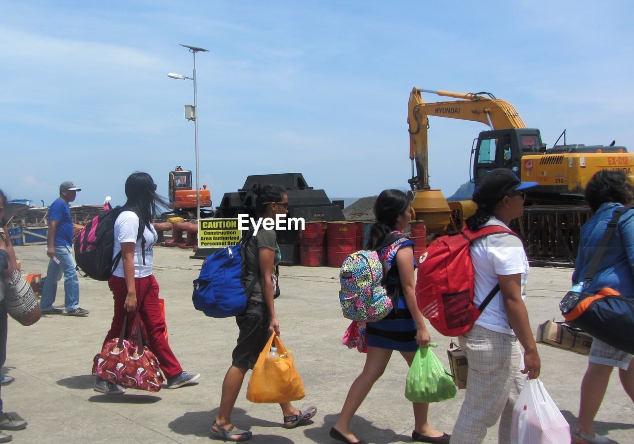 REAR VIEW OF PEOPLE WALKING IN CITY