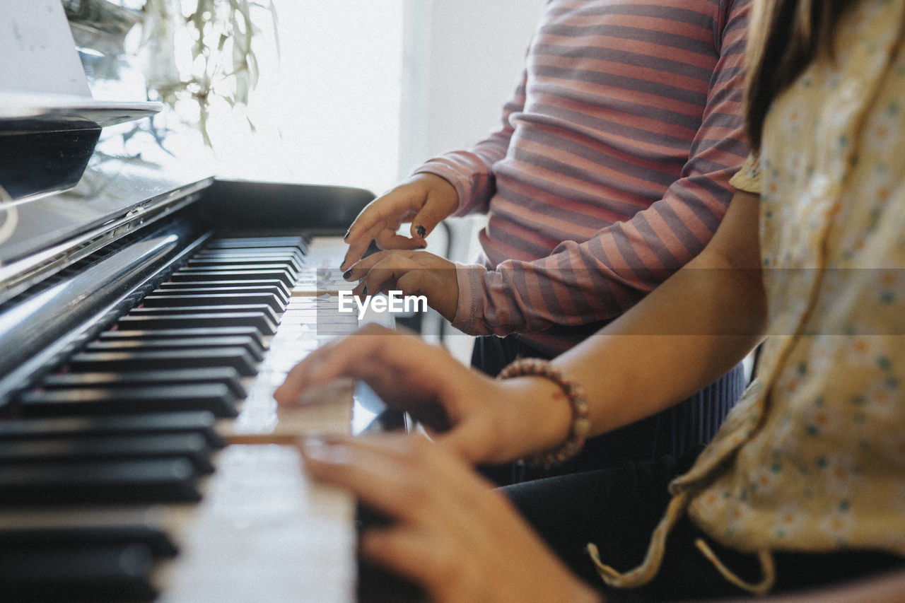 Sisters bonding over playing piano together