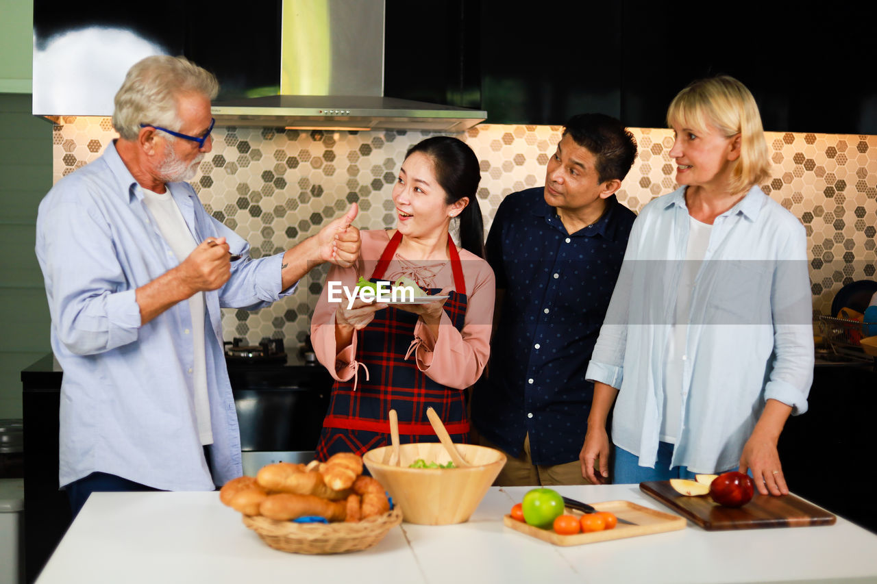 GROUP OF PEOPLE HAVING FOOD AT RESTAURANT