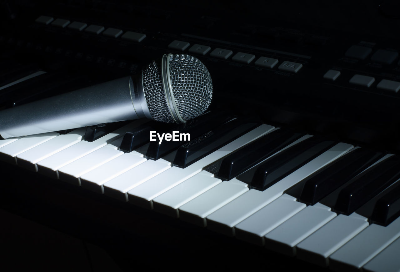 Close-up of microphone on piano keys