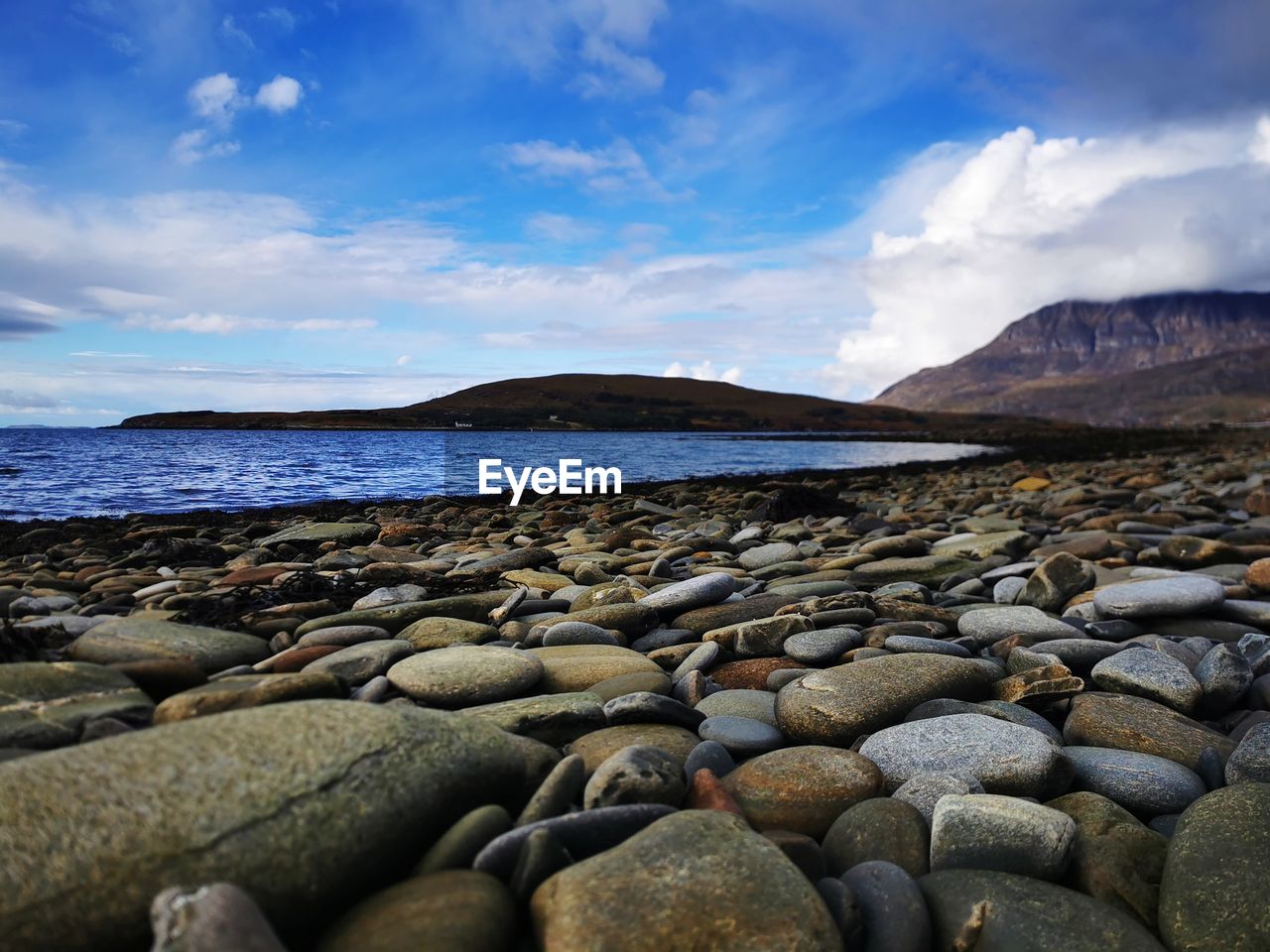 ROCKS ON SHORE AGAINST SKY