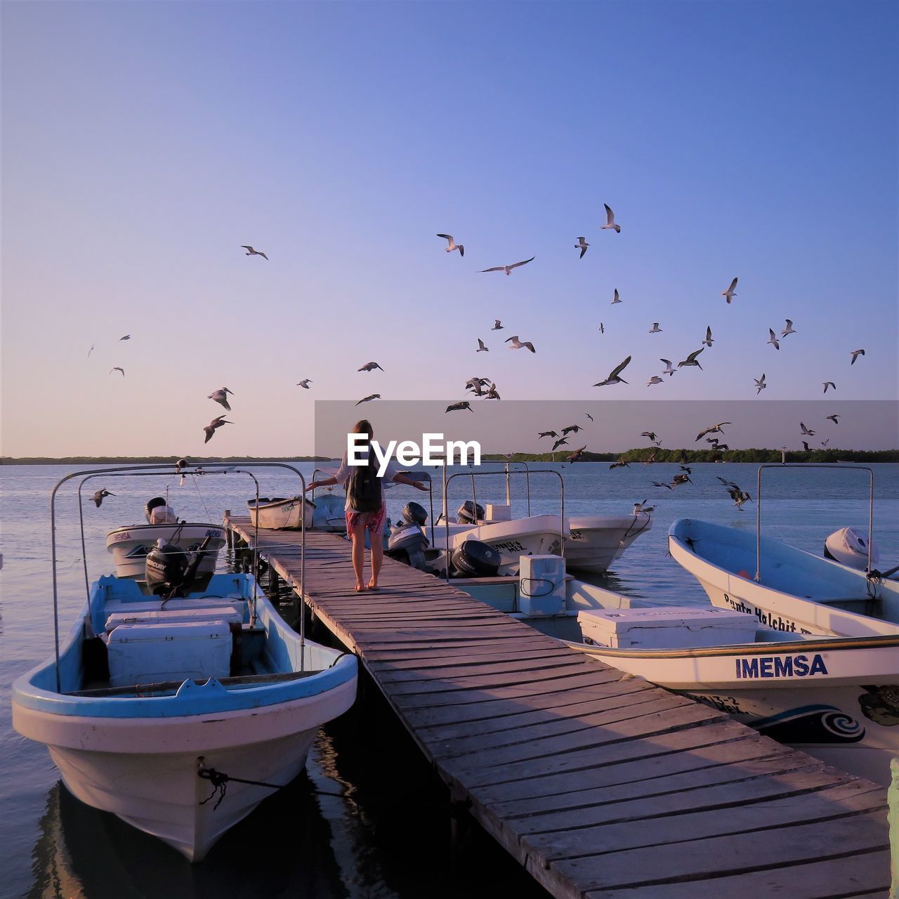 BOATS MOORED ON BEACH AGAINST CLEAR SKY