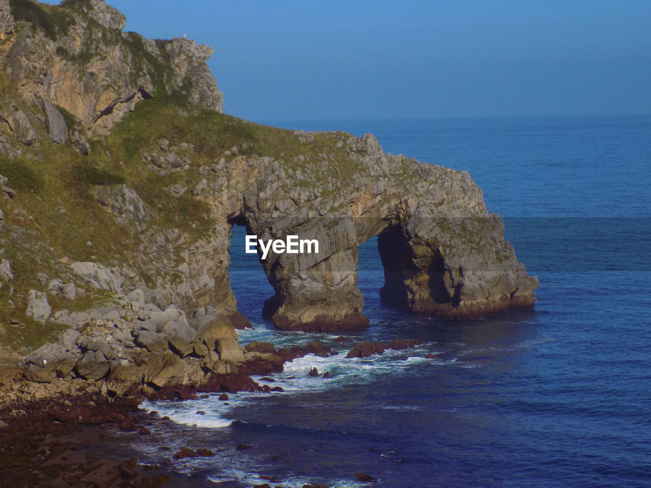 Rock formation in sea against sky