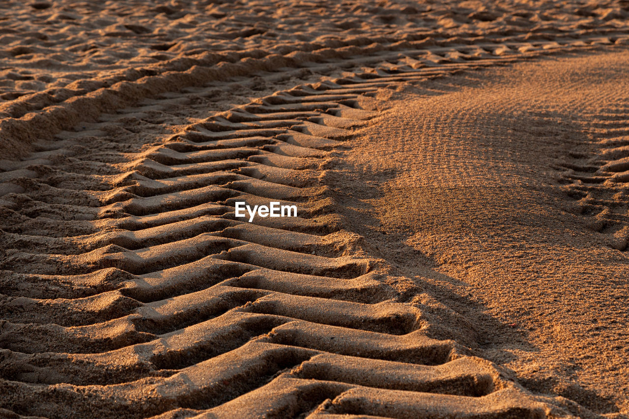 HIGH ANGLE VIEW OF TIRE TRACKS ON DESERT