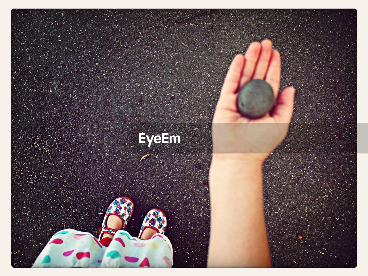 Low section of girl holding stone