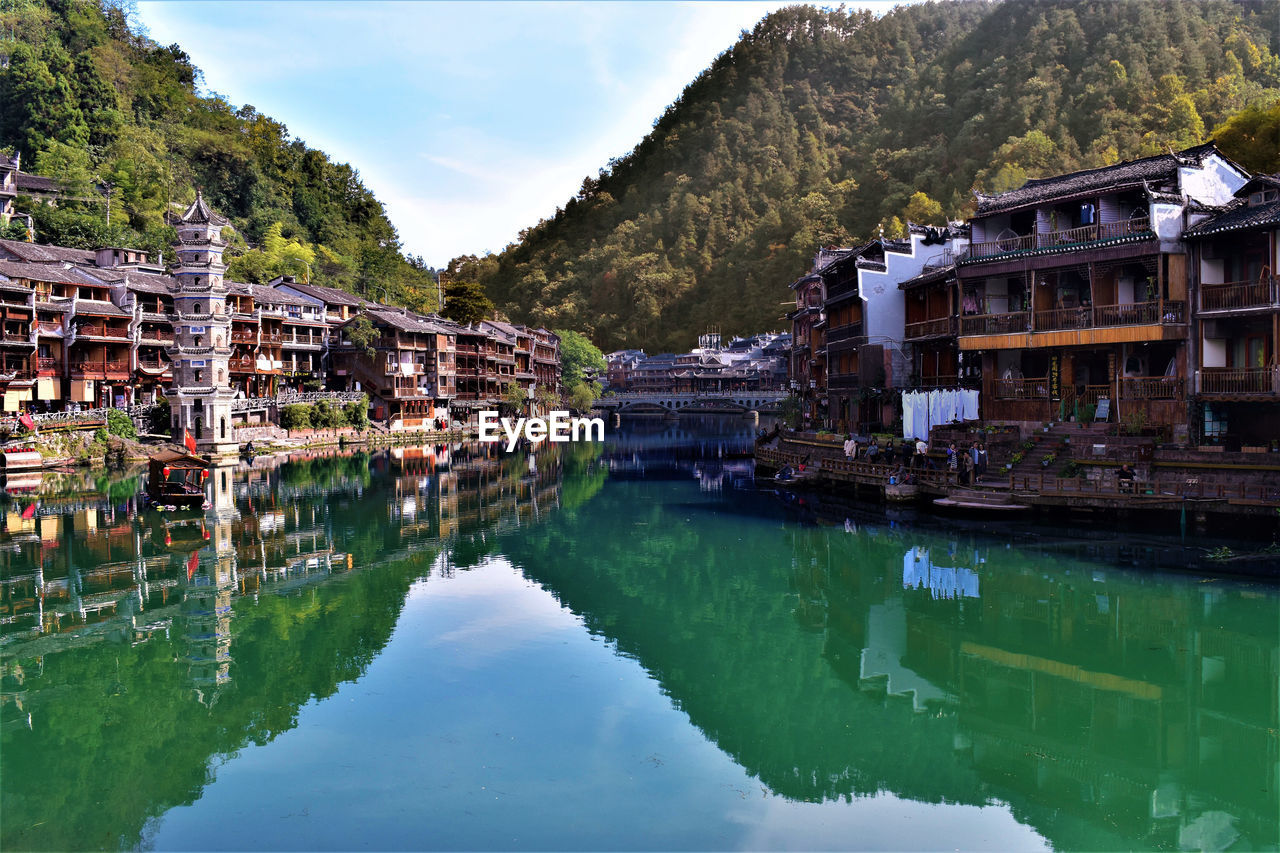 Reflection of buildings in lake against sky