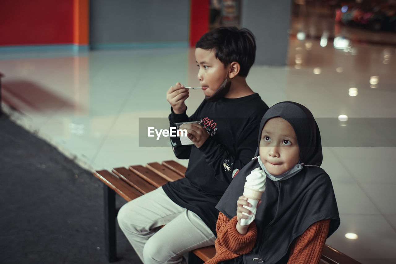 Portrait of young woman and boy sitting at home