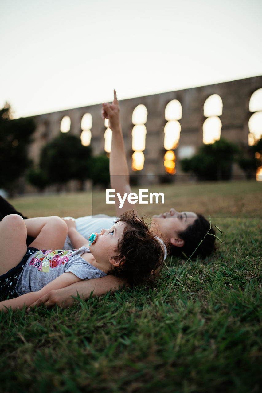 High angle view of mother and girl lying on field