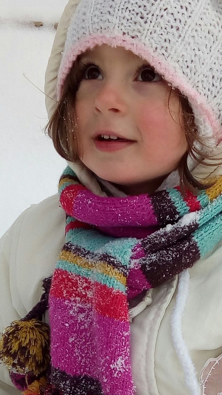 Close-up of girl in warm clothing looking away