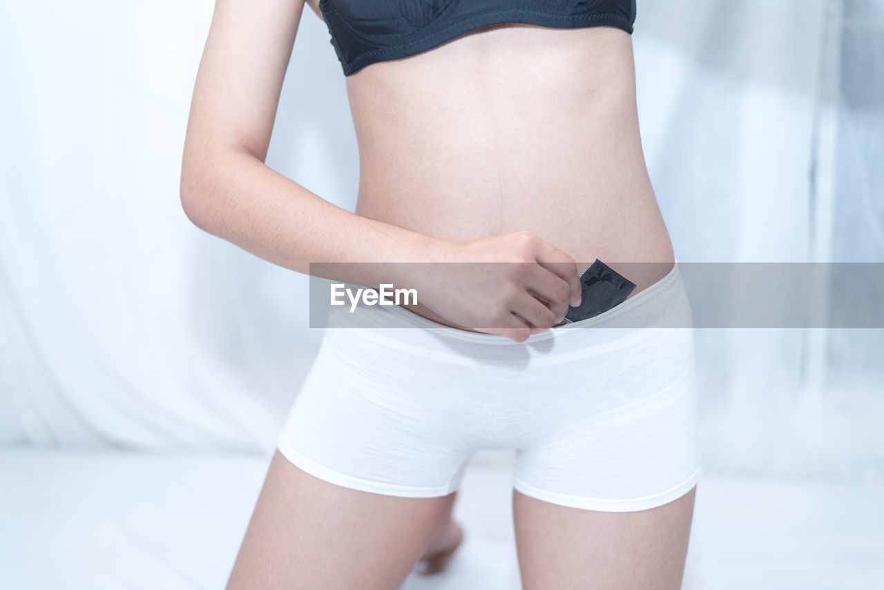 Midsection of woman holding condom