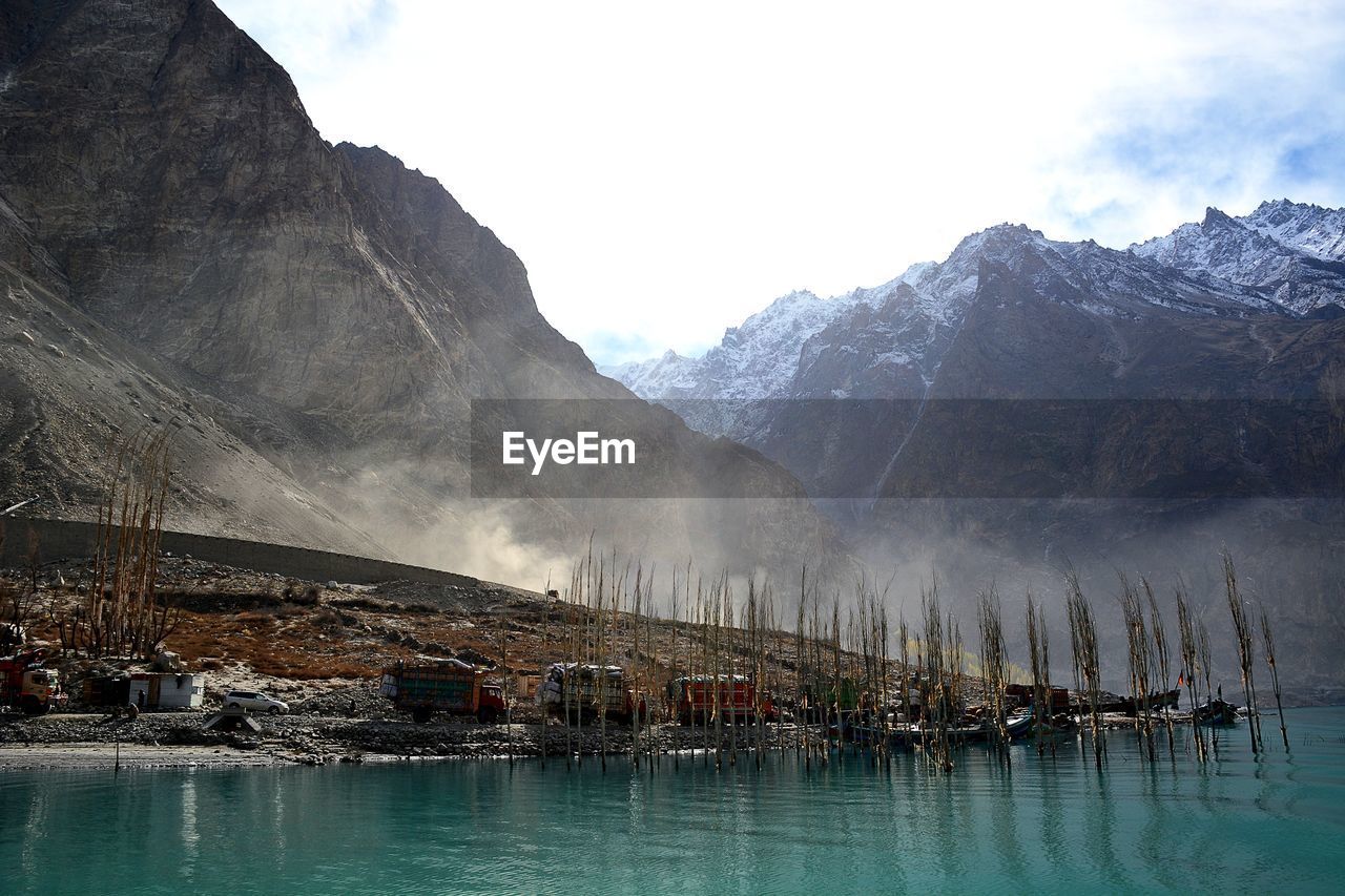 Scenic view of lake by mountains against sky