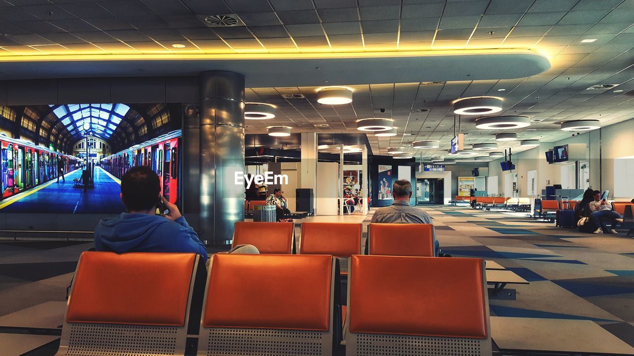 REAR VIEW OF PEOPLE SITTING IN SUBWAY