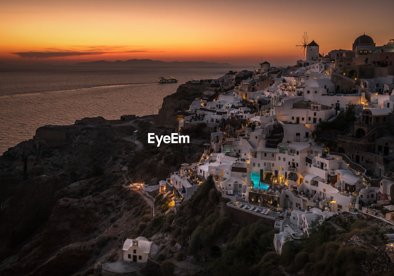 High angle view of oia village by sea at santorini during sunset