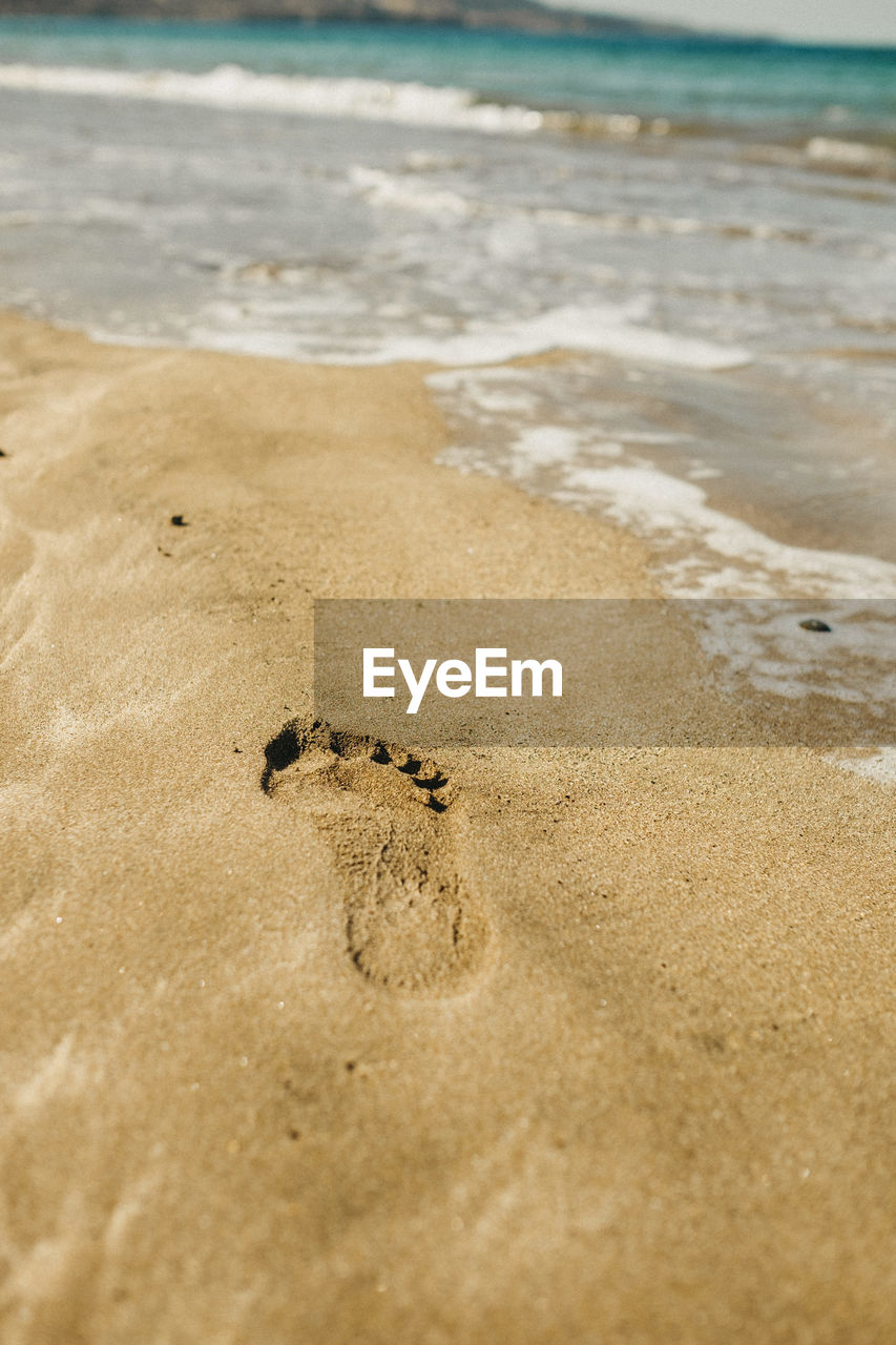 HIGH ANGLE VIEW OF FOOTPRINTS ON SAND