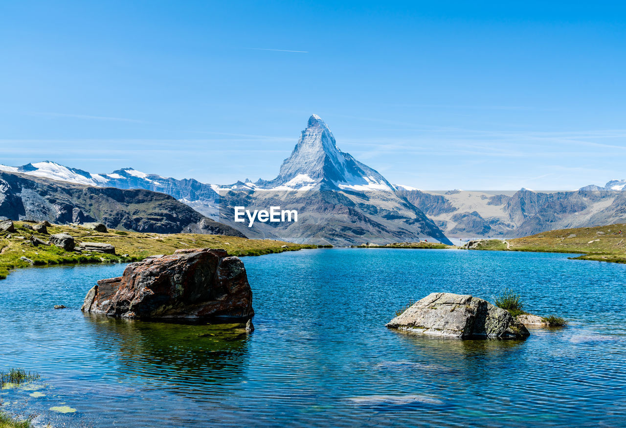 Scenic view of lake and snowcapped mountains against sky