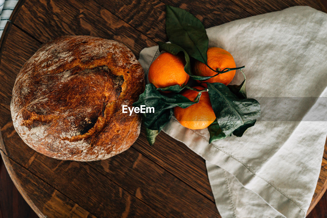 Rustic bread loaf and clementines on the vine