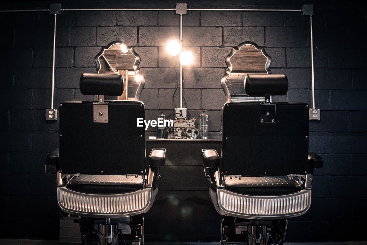Empty chairs at illuminated barber shop