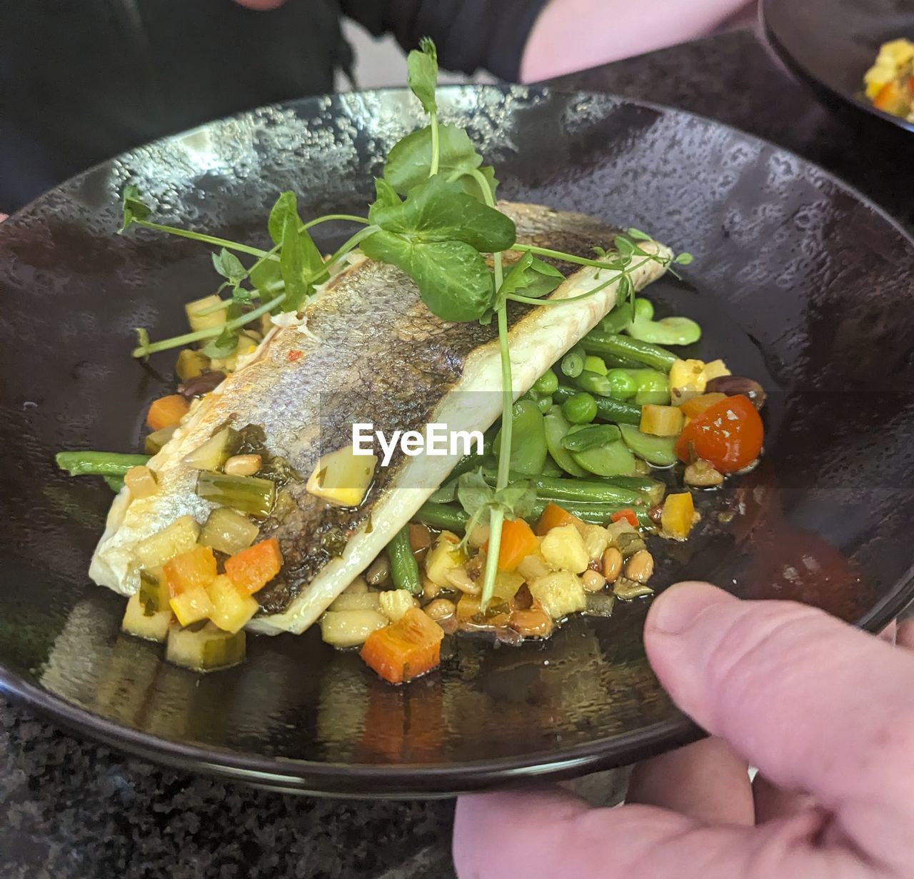 food, food and drink, hand, healthy eating, vegetable, dish, freshness, one person, wellbeing, produce, meal, cuisine, holding, kitchen utensil, lifestyles, adult, wok, herb, indoors, high angle view, cooking pan, close-up, preparing food, household equipment, personal perspective, salad