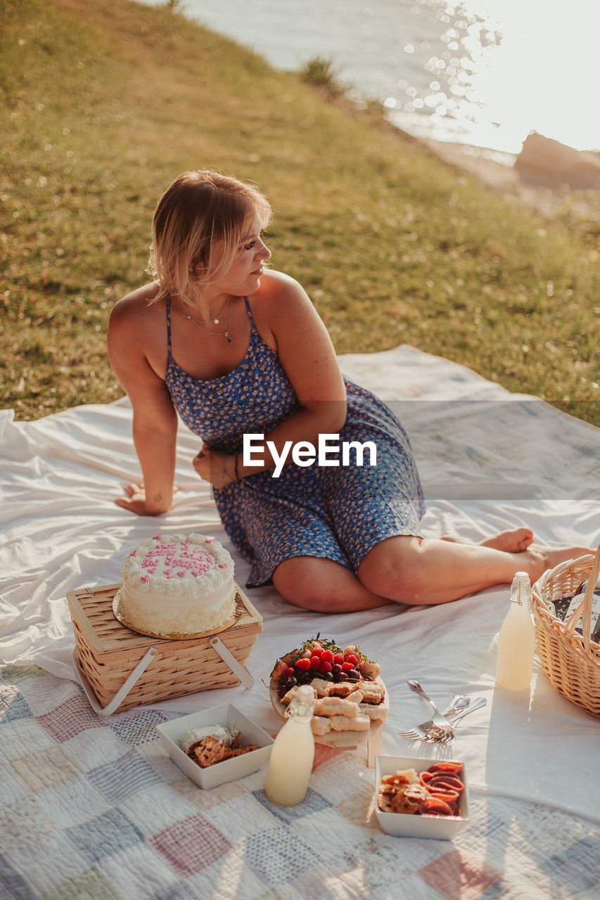 side view of woman sitting on beach