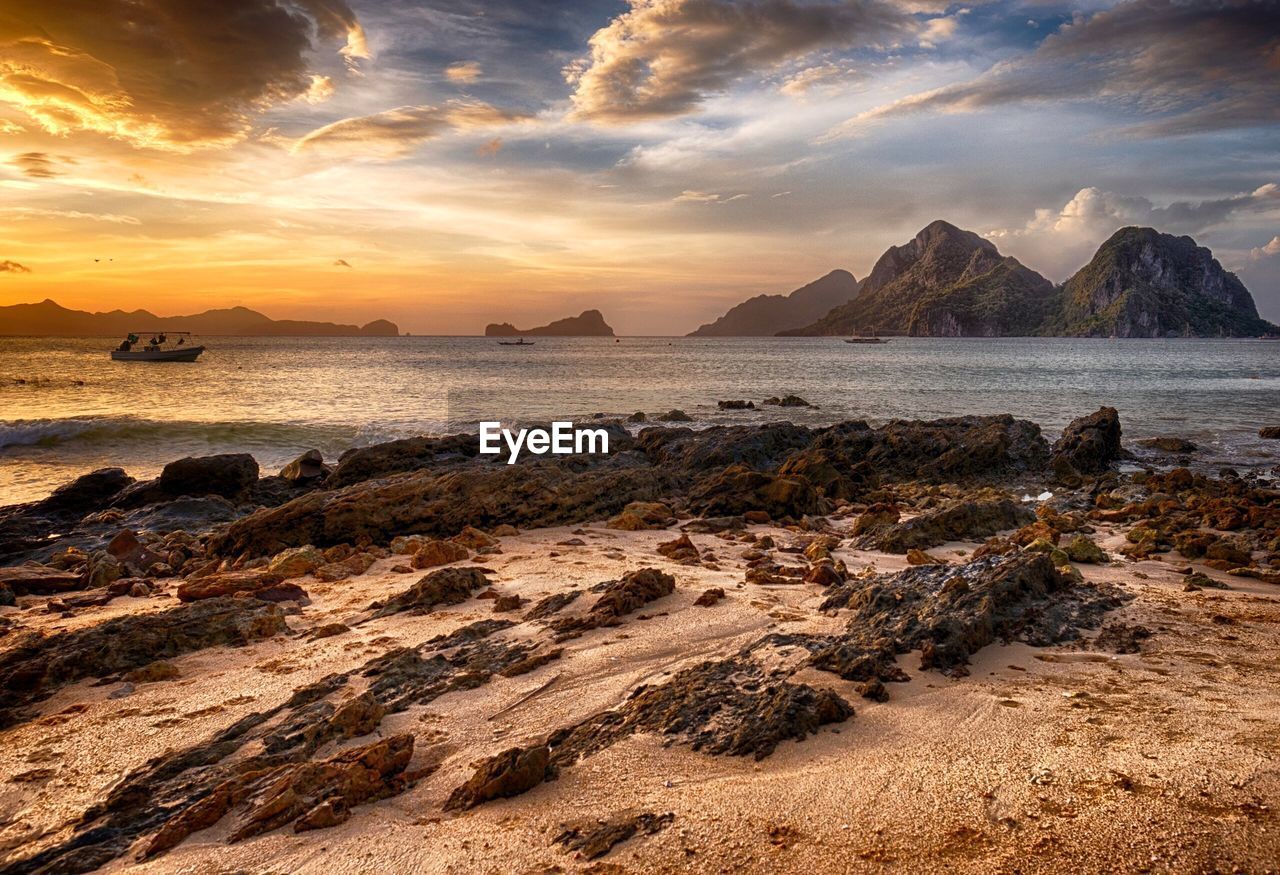 Scenic view of sea against dramatic sky at sunset