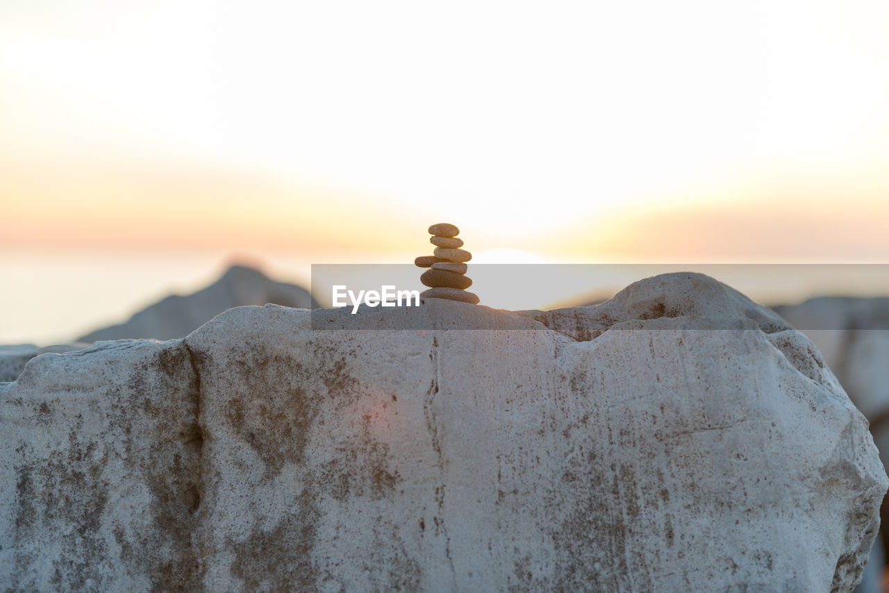 CLOSE-UP OF ROCK AGAINST SEA AT SUNSET