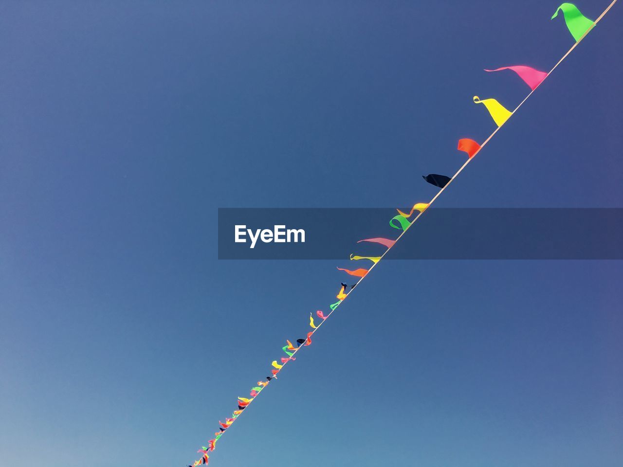 Low angle view of buntings against clear blue sky